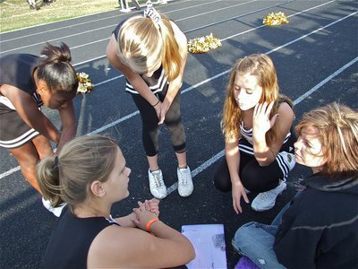 Image: Cheerleaders huddle — Cheerleader coach Darla Wood huddles with the young ladies to decide the next cheer.