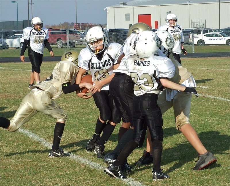 Image: Going for the strip — Ryan Connor(18) tries to strip the ball away from the Bulldogs.