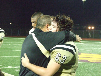 Image: It’s been a great season — Coach Bales and his assistant coaches take a moment at the end of the game to thank each Gladiator for a job well done.  Here Coach Bales is thanking Zach Hernandez.