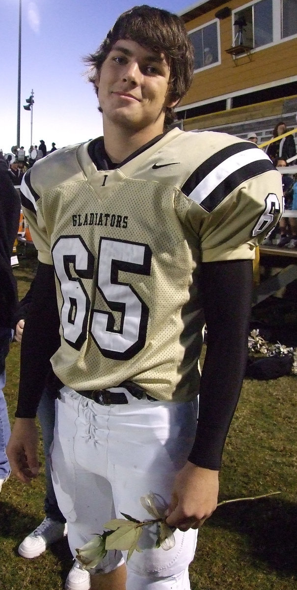 Image: Jonathan Nash — A humbled Jonathan Nash prepares to give a rose to his mother on Senior Night.