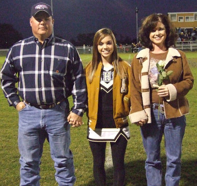 Image: Drew Windham — Senior Drew Windham stands proud with her parents, Andrea &amp; Joe Windham on Senior Night.