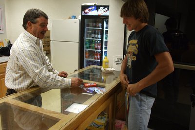 Image: Avalon vs Lady Gladiators — Board member Larry Eubank works the concession stand and sells Clay Major a candy bar.