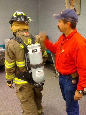 Image: Oxygen Tank — The oxygen tank is strapped on the fireman.