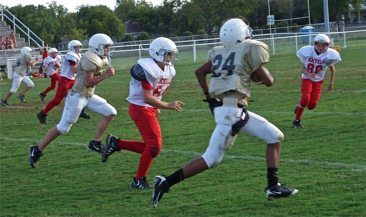 Image: Robertson’s loose — Trevon Robertson(24) takes the edge as the Longhorn defense tries to fence him in.