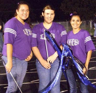 Image: IHS Flag Corp — Nikki Brashear, Megan Buchanan and Yesenia Lopez, members of the Italy Regiment Band Flag Corp, get ready for the halftime performance.