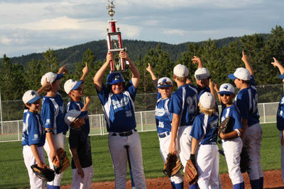 Image: Luke Morton triumphs — Luke Morton (#35) raises his 2nd Place trophy and the confidence of his teammates after competing in the Home Run Derby.