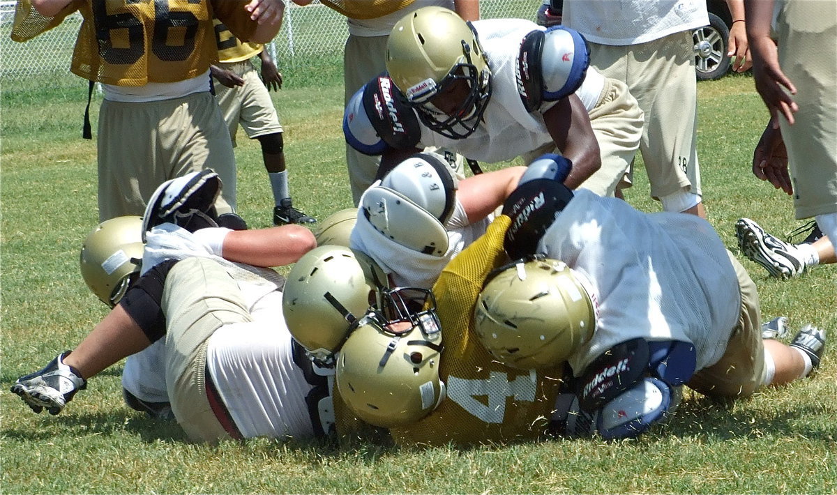 Image: Tony is tough — J.V. sophomore quarterback Tony Wooldrige(4) gets mowed over by Italy’s Varsity.