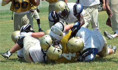 Image: Tony is tough — J.V. sophomore quarterback Tony Wooldrige(4) gets mowed over by Italy’s Varsity.