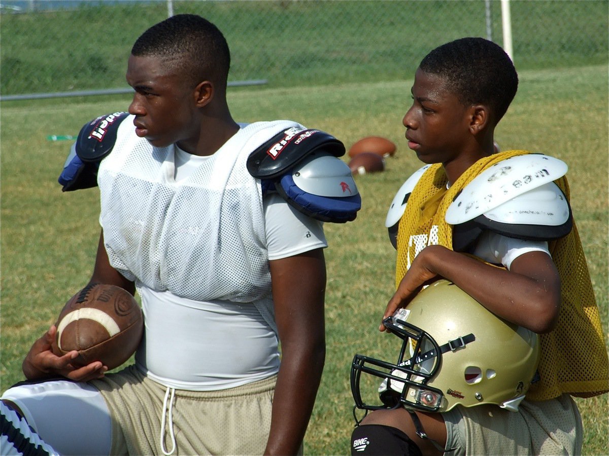 Image: Beast and Mini Beast — Jasenio Anderson and Eric Carson listen to defensive coordinator Jeff Richters’ thoughts of wisdom.