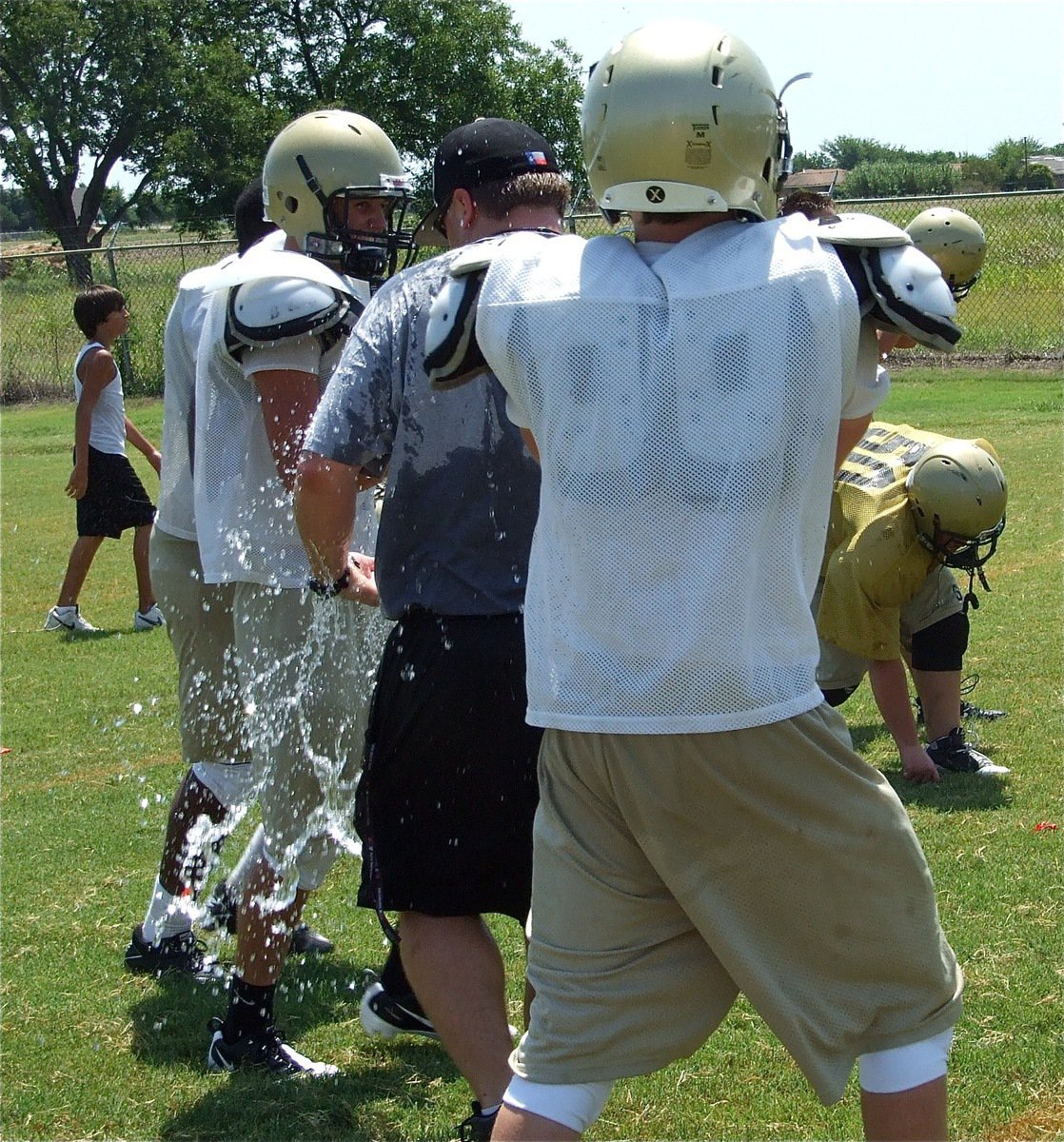 Image: Sneak attack — Justin Buchanan catches coach Josh Ward from behind with a water balloon.