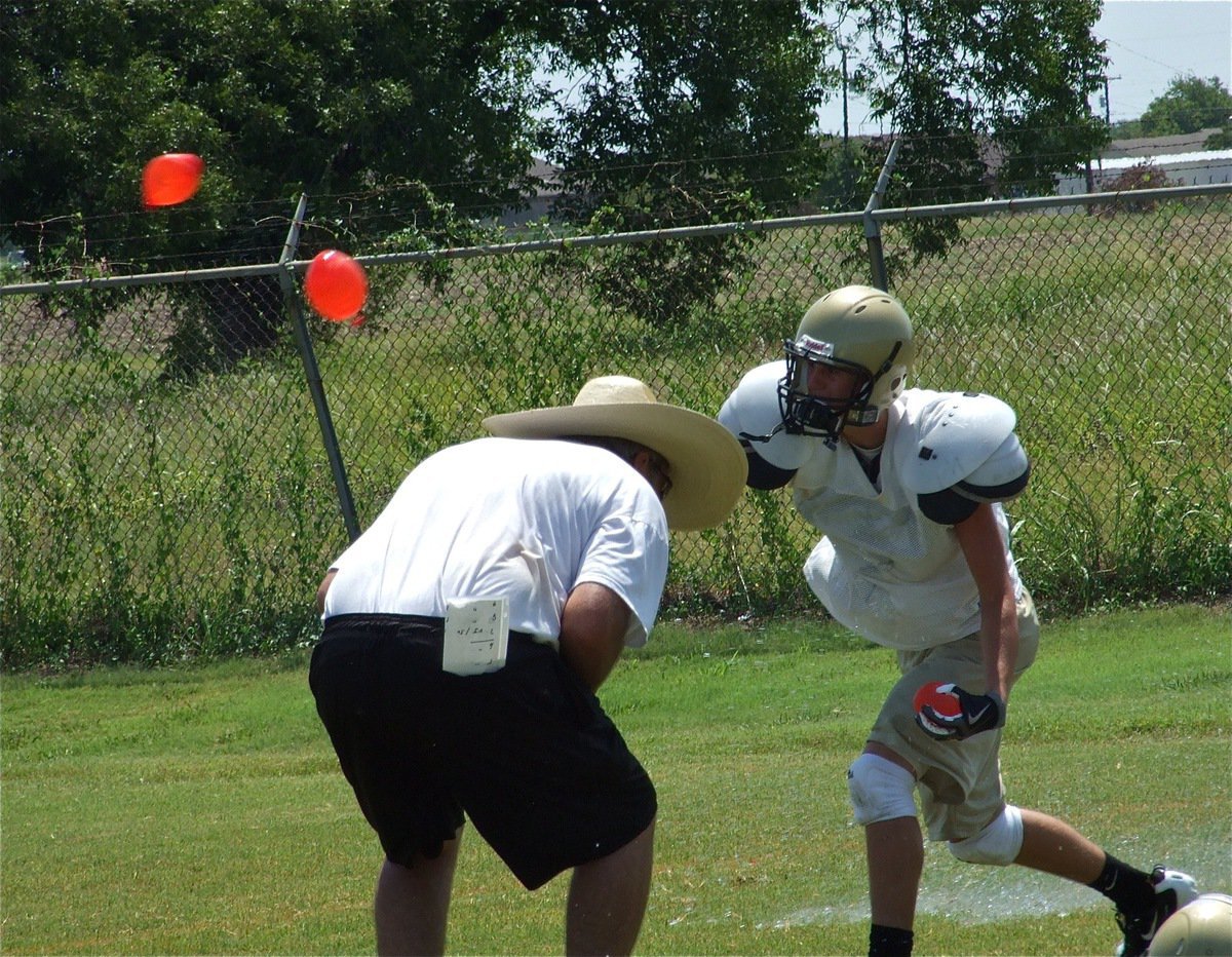 Image: Duck! — Line coach Stephen Coleman tries to avoid the onslaught of water balloons thrown by Jase Holden and his teammates.