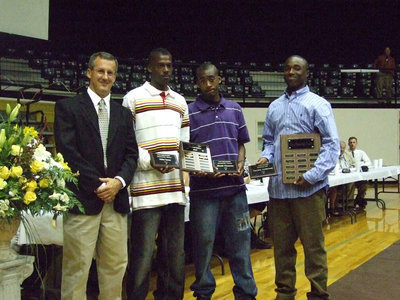 Image: Varsity Basketball Boys — (L-R) Coach Kyle Holley, John Isaac, Heath Clemons and Jasenio Anderson.