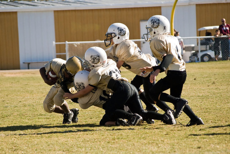 Image: Who Let The Dogs Out? — Ricky Pendleton is brought down by a pack of Bulldogs.