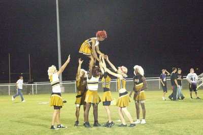 Image: The cheerleaders — The cheerleaders attempt to “fly” for the crowd.