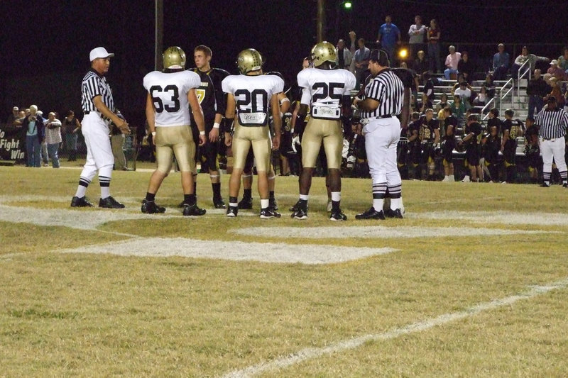 Image: Captains meet — Zach Hernandez #63, Clay Major #20 and Diamond Rodgers #25 meet Dawson captains with the referees before the game.