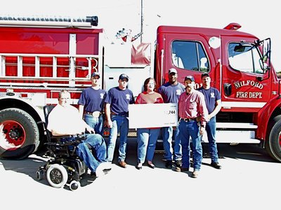 Image: Firefighters receive grant — Mayor John Knight, Travis Nelson, Andy Frank, Peggy Duke from Fireman’s Fund Insurance company, Alan Singleton, Chief Mark Jackson, and Scott Kelley all on hand to receive the grant for new bunker gear.