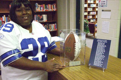 Image: Proud Mom — Brenda Davis proudly shows off the autographed football and her son’s jersey.