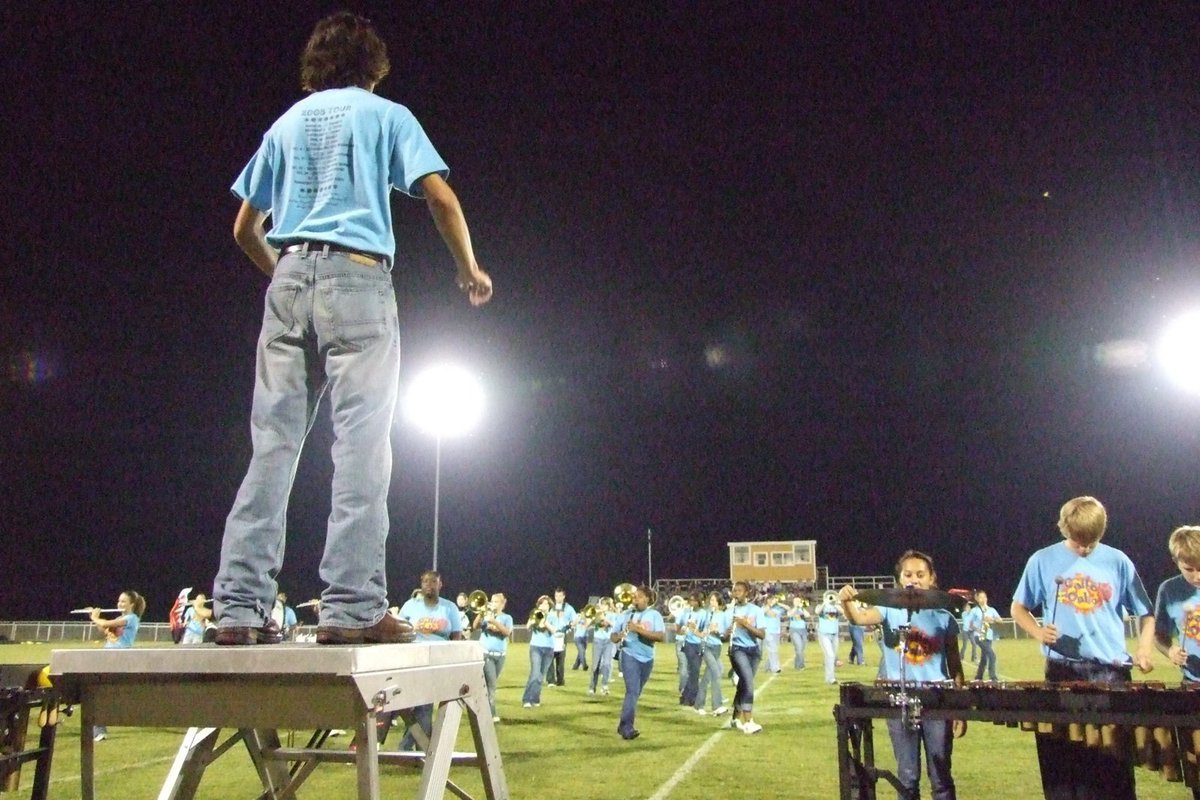 Image: Band moves in formation — Drum major, Chase Michaels, leads the band in halftime performance.