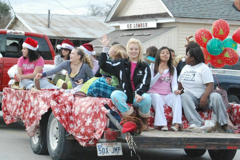 Image: Doing The Wave — The Italy Lady Gladiators wave to the festival crowds as their parade float passes.