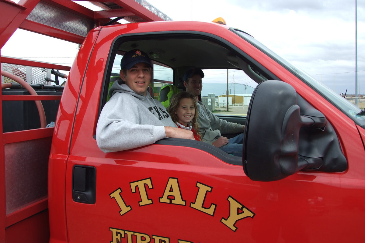 Image: Italy Fire Department Celebrates — Italy Fire Department volunteers relied on bright smiles and bright red engines to light up the parade.