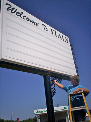 Image: Nice Touch — A member of the Russell Byrum Sign crew adds the finishing touches.