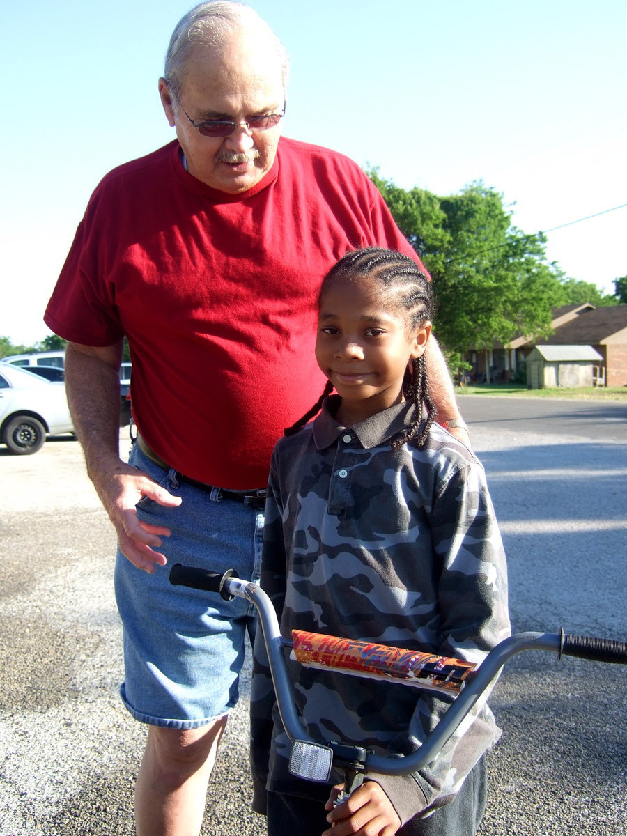 Image: Freddie Ivy and Sam Glover smiling for the camera. Sam is very happy to get his bike.