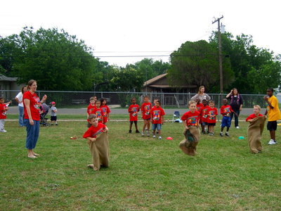 Image: These kindergartners are hopping to the finish line in the sack race.