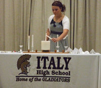 Image: Shelbi Gilley lights a candle that represents Service at the NHS ceremony on Tuesday night.