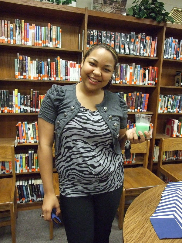 Image: Destani Anderson enjoys punch and cookies in the library after the induction ceremony.