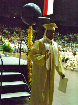 Image: DeAndre Rettig crosses the stage with that diploma he earned.
