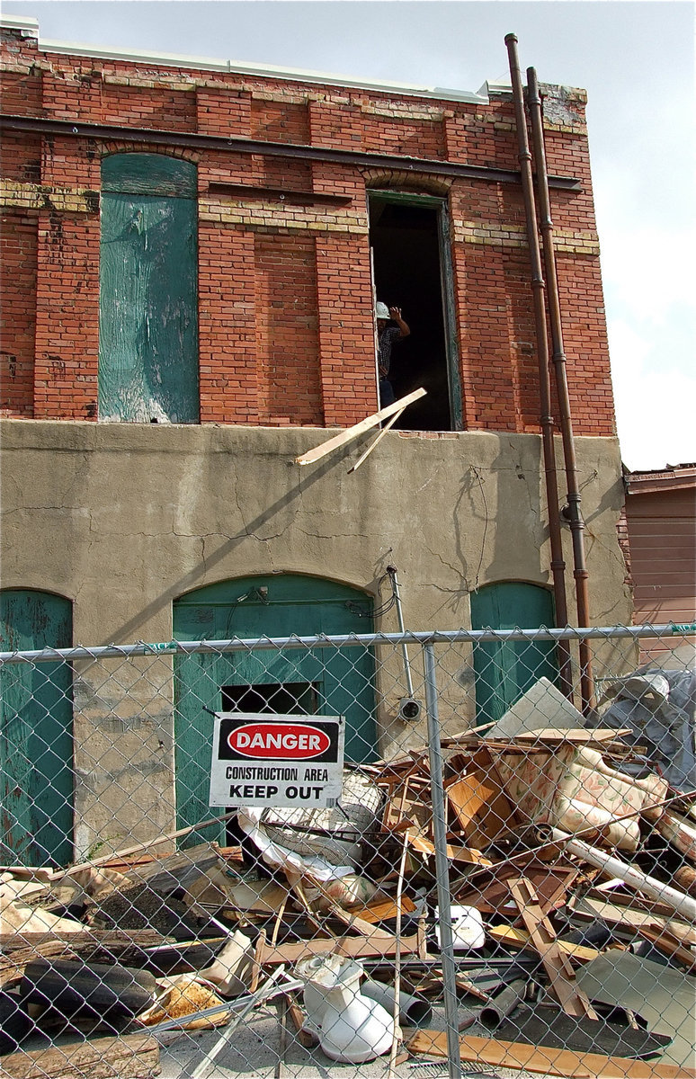 Image: Demolition workers toss debris from the second-floor of the community center.