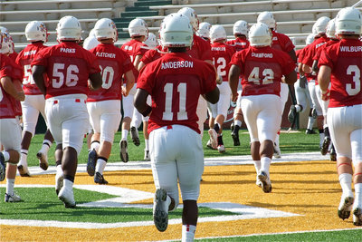 Image: Jasenio Anderson(11) and his FCA Red Teammates jog back into the locker room to get padded up before game time.