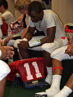 Image: Quarterback and kicker, Jasenio Anderson(11), takes a moment to collect his thoughts inside the Red Team’s locker room.