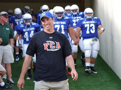 Image: The FCA Blue Team exits the tunnel and takes the field led by Corsicana’s head football coach, Phil Castles, and Fairfield’s, Dominique Owens(71).