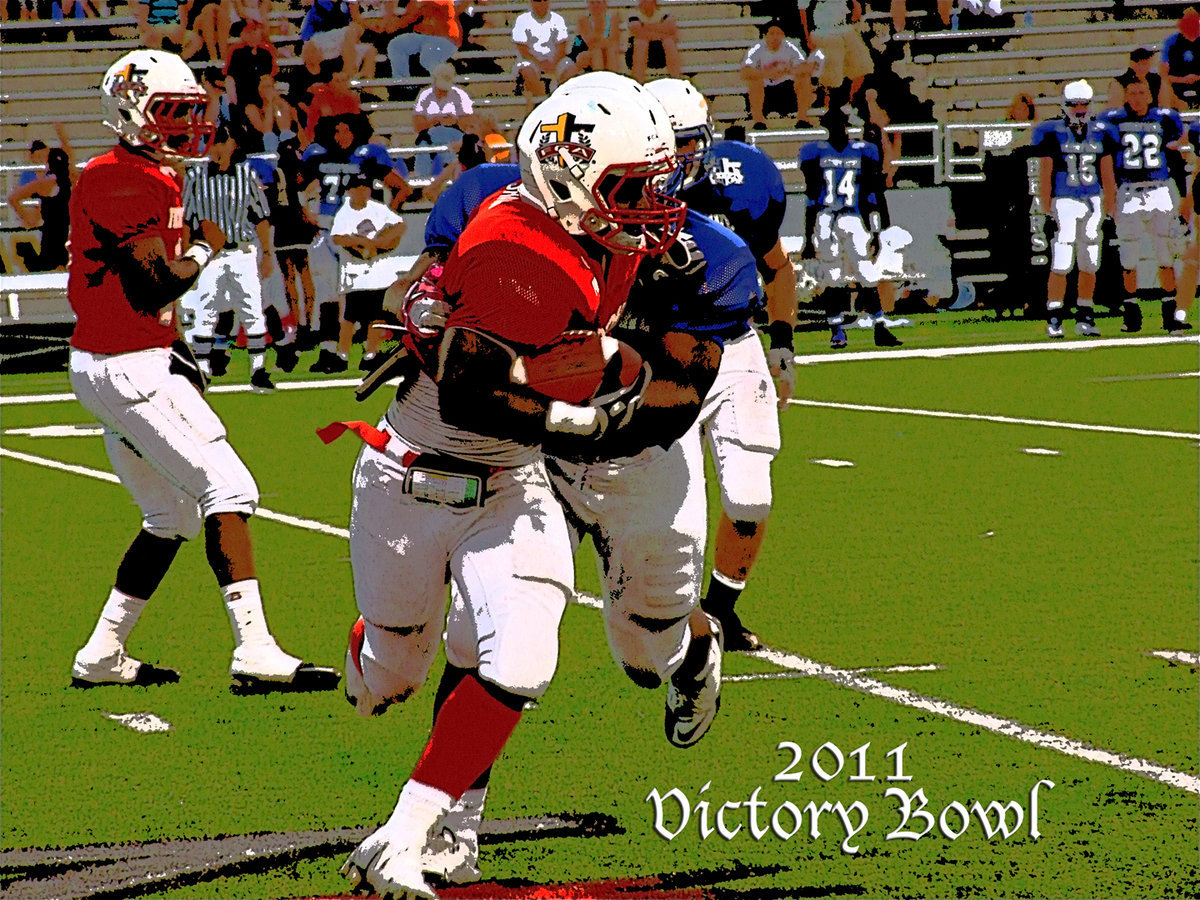 Image: Italy’s Jasenio Anderson(11) hands off to Dawson’s Alex Shaw(1), who tries to break away from Blue Team defenders during the 2011 Victory Bowl of consisting of senior All-Stars.