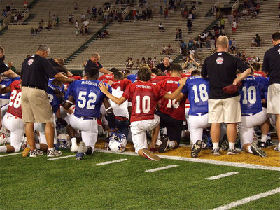 Image: After the Victory Bowl game came to an end, both sidelines united for a group prayer at center field.