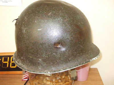 Image: The helmet Bell wore when a bullet hit him in the head. The bullet entered on the side of his helmet.