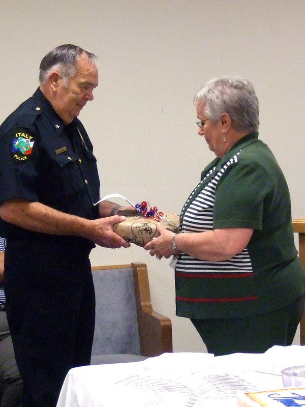 Image: Chief Johns accepting a gift from his police officers. Police secretary Sue is honored to present the gift.