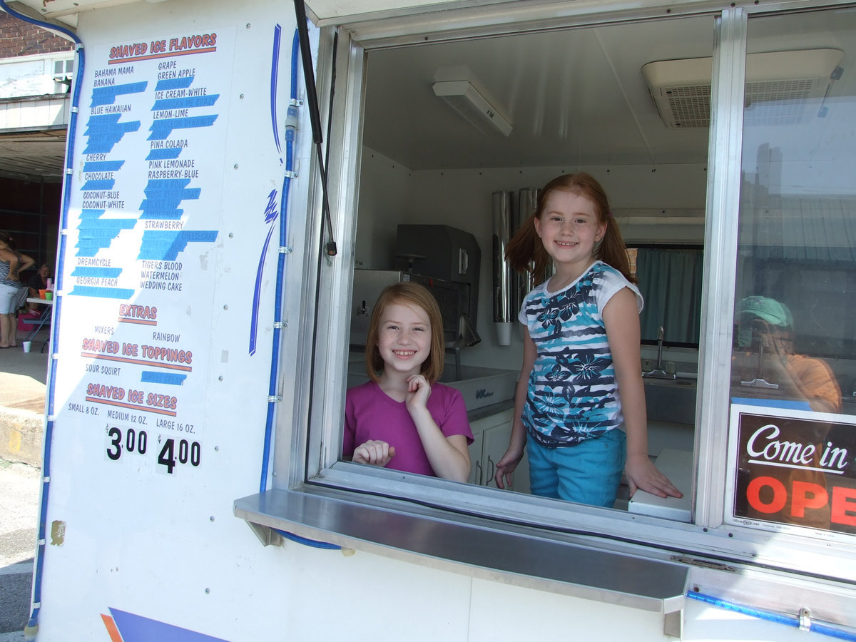 Image: Selling shaved ice in all kinds of flavors are Allison, age 7, and Jaqlyn, age 9.