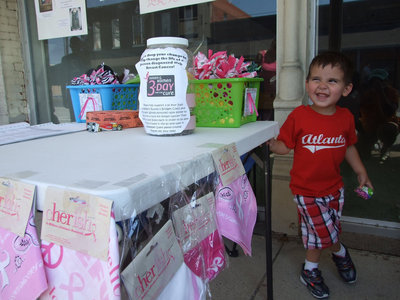Image: Little 3 year old Gabriel Antunez is helping his mom at this booth.  To help with the Susan G. Komen 3-Day Walk, Russell &amp; Bridgette Coers and Mistiann Antunez each need $2300 to walk in November.