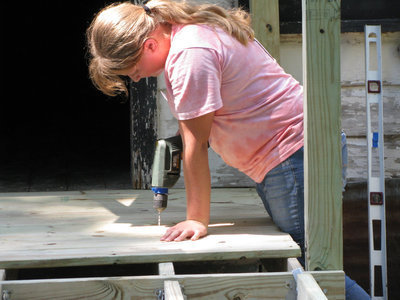 Image: This young lady from the mission trip learned drilling techniques.