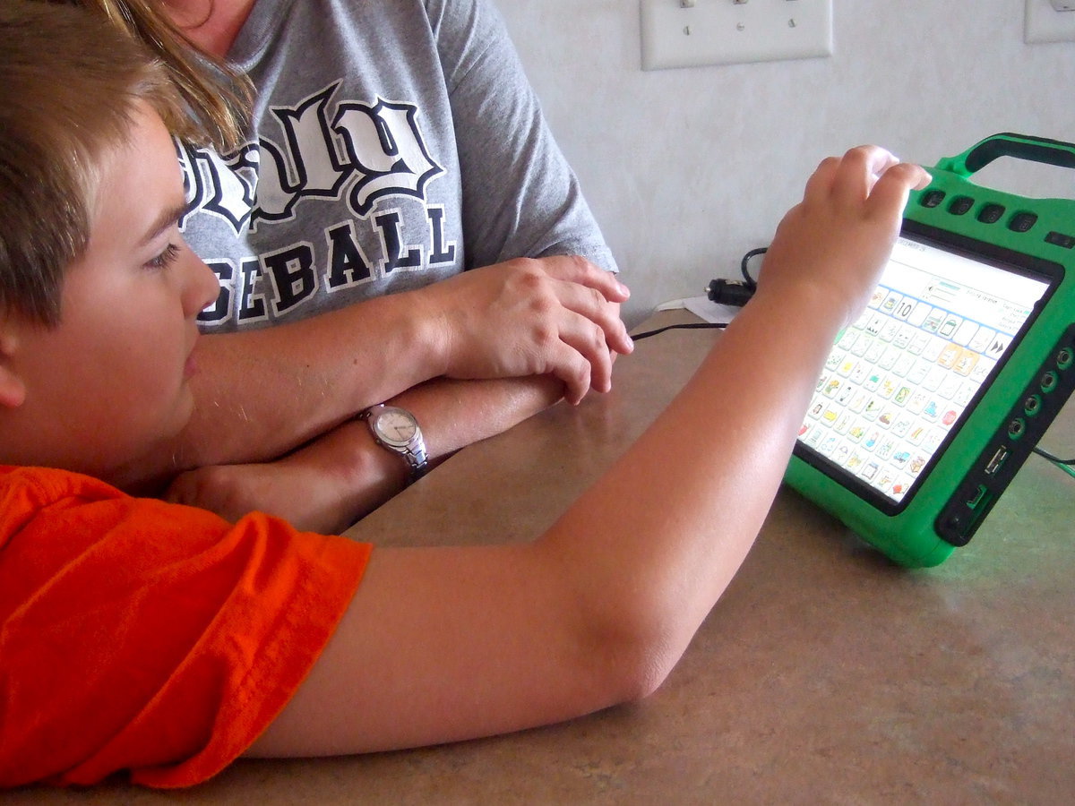 Image: Wyatt demonstrating how he uses his communication device.