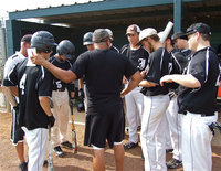 Image: Coaches Mark Jacinto and brother, Vincent Jacinto, talk with the team before the first pitch.