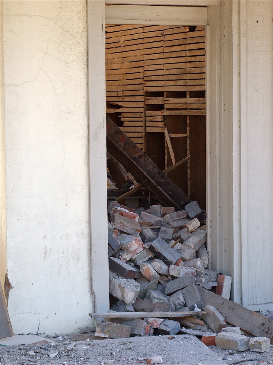 Image: Damaged bricks roll out the door and on to the sidewalk.