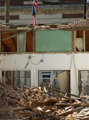 Image: As if it were a war zone, the old community center battled until the end as its remains are reflected in the windows of Italy City Hall across the Main Street.