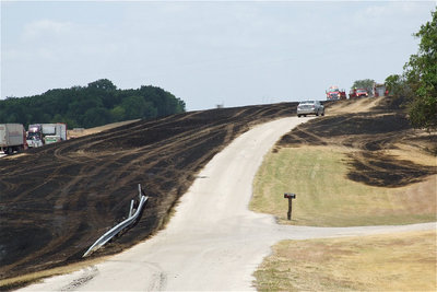 Image: The bus fire sparked a grass fire that left several acres of land scorched beyond Highway 35.