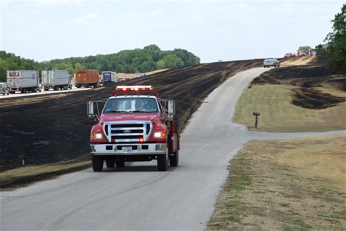 Image: Italy fire crews search for potential flare ups along the roadside.