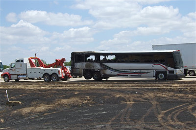 Image: Helms Garage tows away the passenger bus that was heading southbound toward Waco before catching fire.
