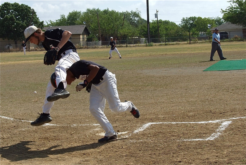 Image: Oops! Just when you thought it was safe to steal home, Italy’s Brandon Souder covers the plate while trying to leap over what he thought would be a sliding Maybank runner.