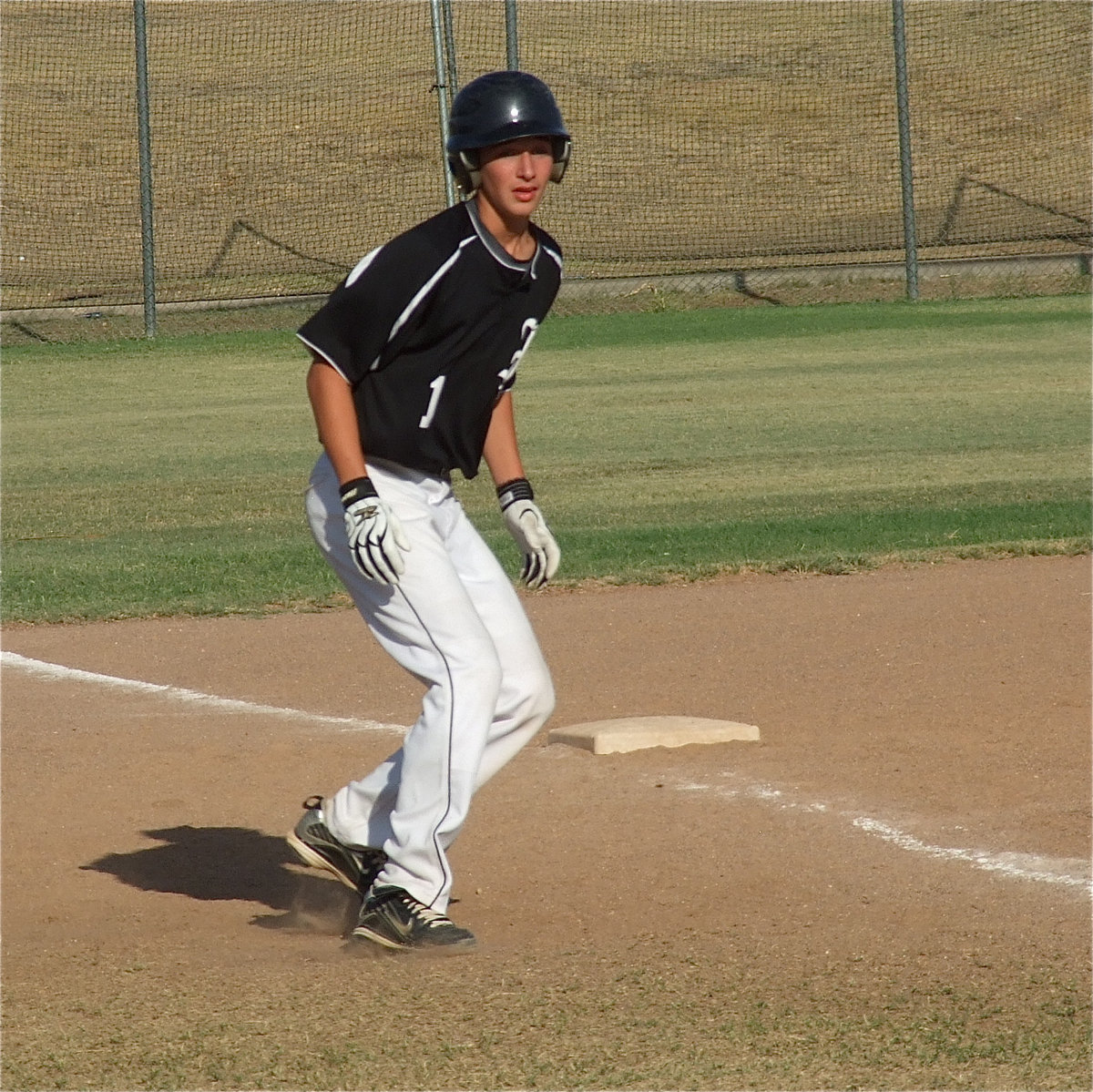 Image: Ross Stiles(1) weighs his options on third base as he considers stealing home.